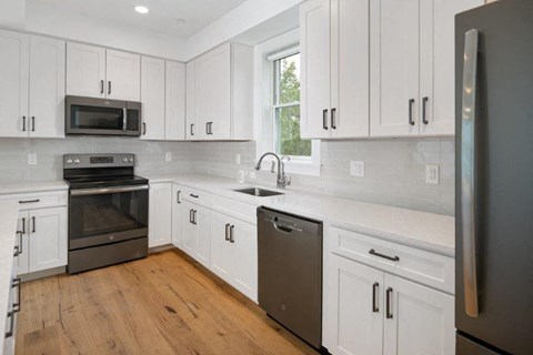 a kitchen with white cabinets and stainless steel appliances